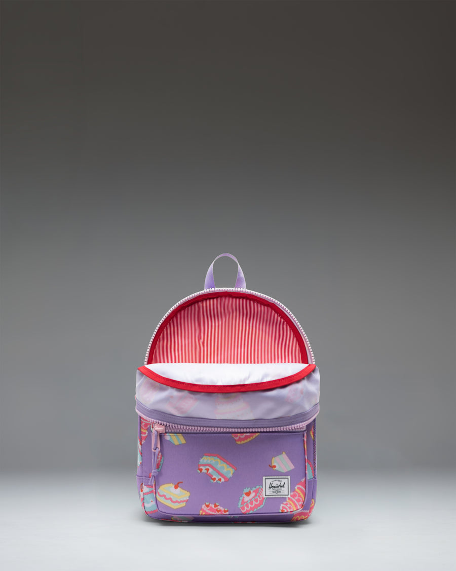 Herschel Heritage Kids Backpack in Cakes colorway, featuring a light blue body patterned with colorful layered cakes and cupcakes.