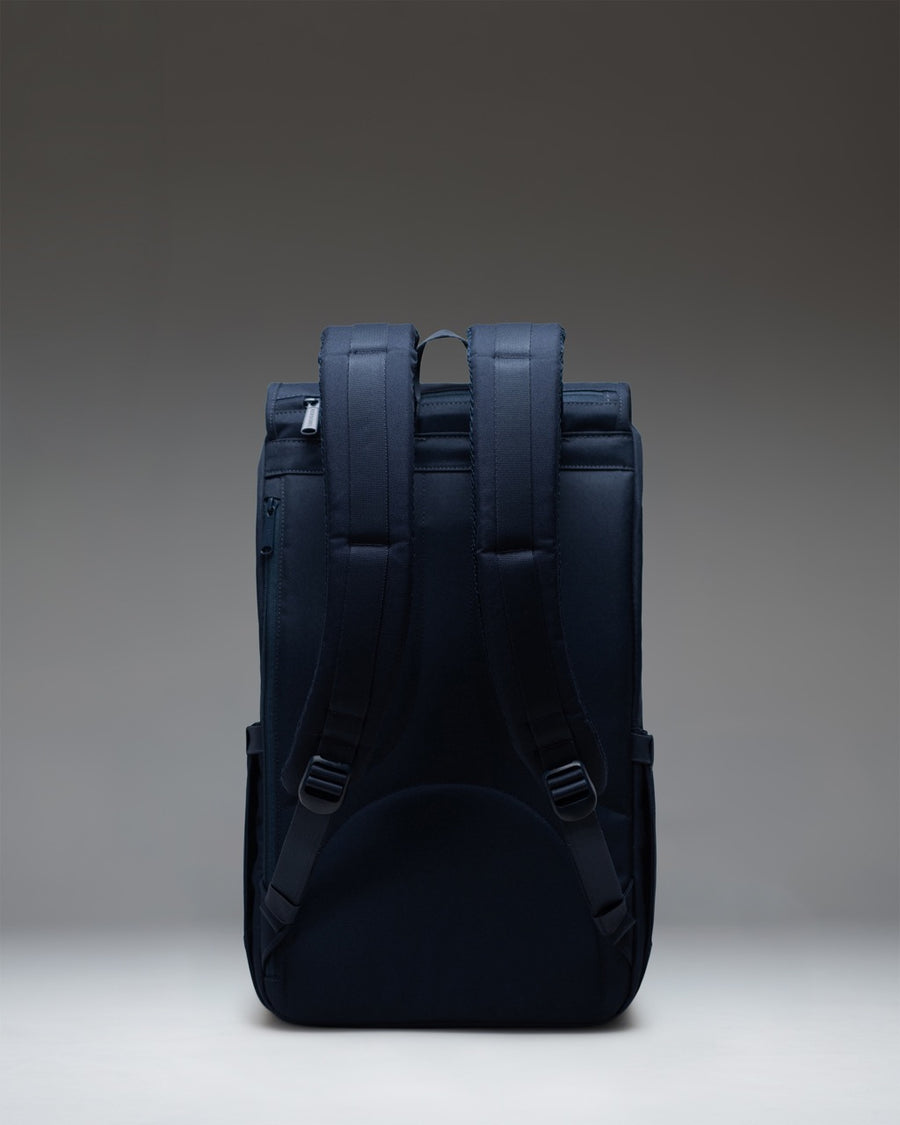 Herschel Little America Backpack in navy blue, featuring classic mountaineering style with front straps and buckles.