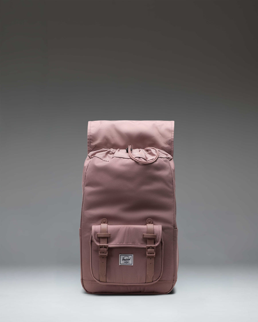 Herschel Supply Co. Little America Mid Backpack in Ash Rose, a light pink urban backpack with magnet-fastened straps and a front storage pocket.