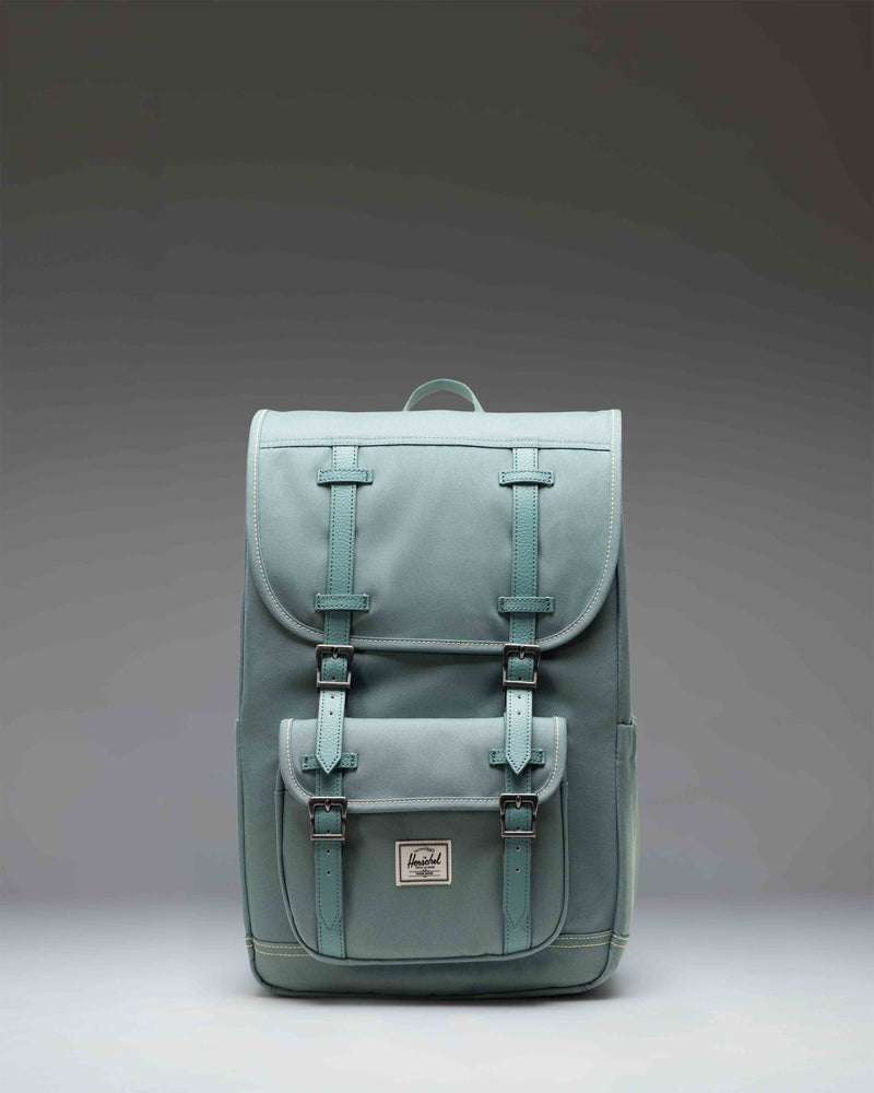 Herschel Little America Mid Backpack in olive green with tan magnetic straps and a front zipper pocket.