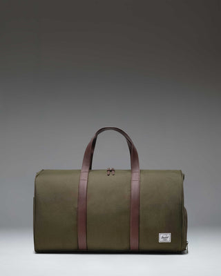 Herschel Novel Duffle bag in Ivy Green, featuring a classic duffle design with top handles, a shoulder strap, and a signature shoe compartment.