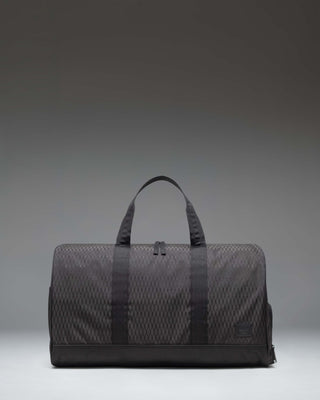 Herschel Novel Duffle bag in Black Diamond/Black color, showing a side view of the clean, textured fabric design with carry handles and shoulder strap.