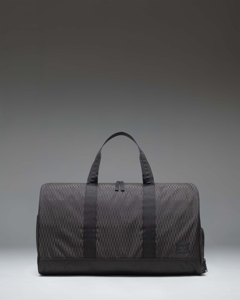 Herschel Novel Duffle bag in Black Diamond/Black color, showing a side view of the clean, textured fabric design with carry handles and shoulder strap.