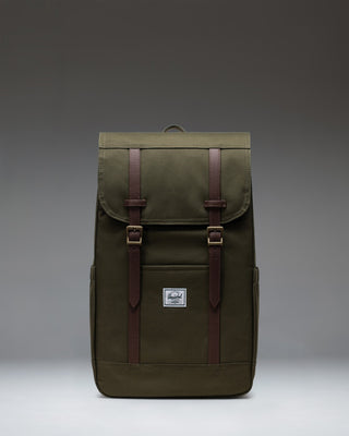 Herschel Retreat Backpack in Ivy Green with brown strap details and a classic woven label on the front.