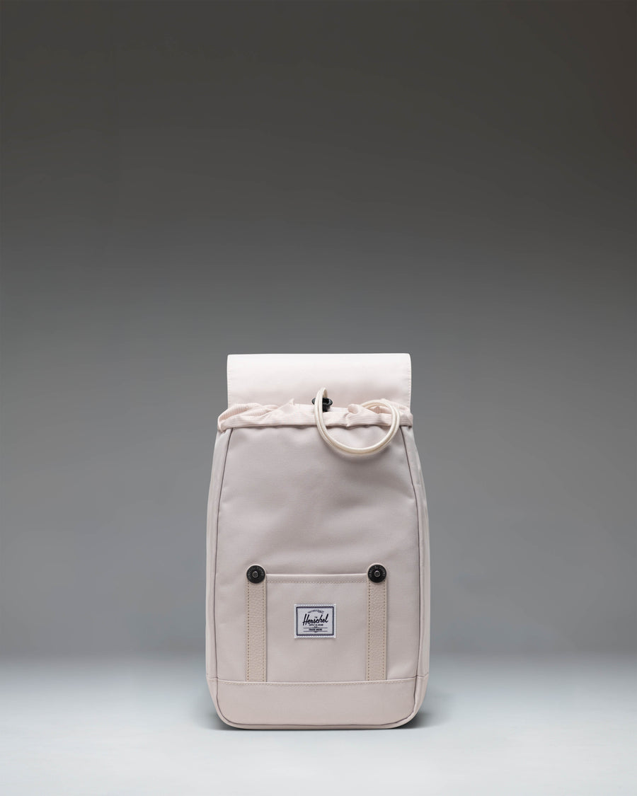 Herschel Retreat Mini Backpack in the light beige Moonbeam colorway, featuring a classic cinch top and front strap closure.