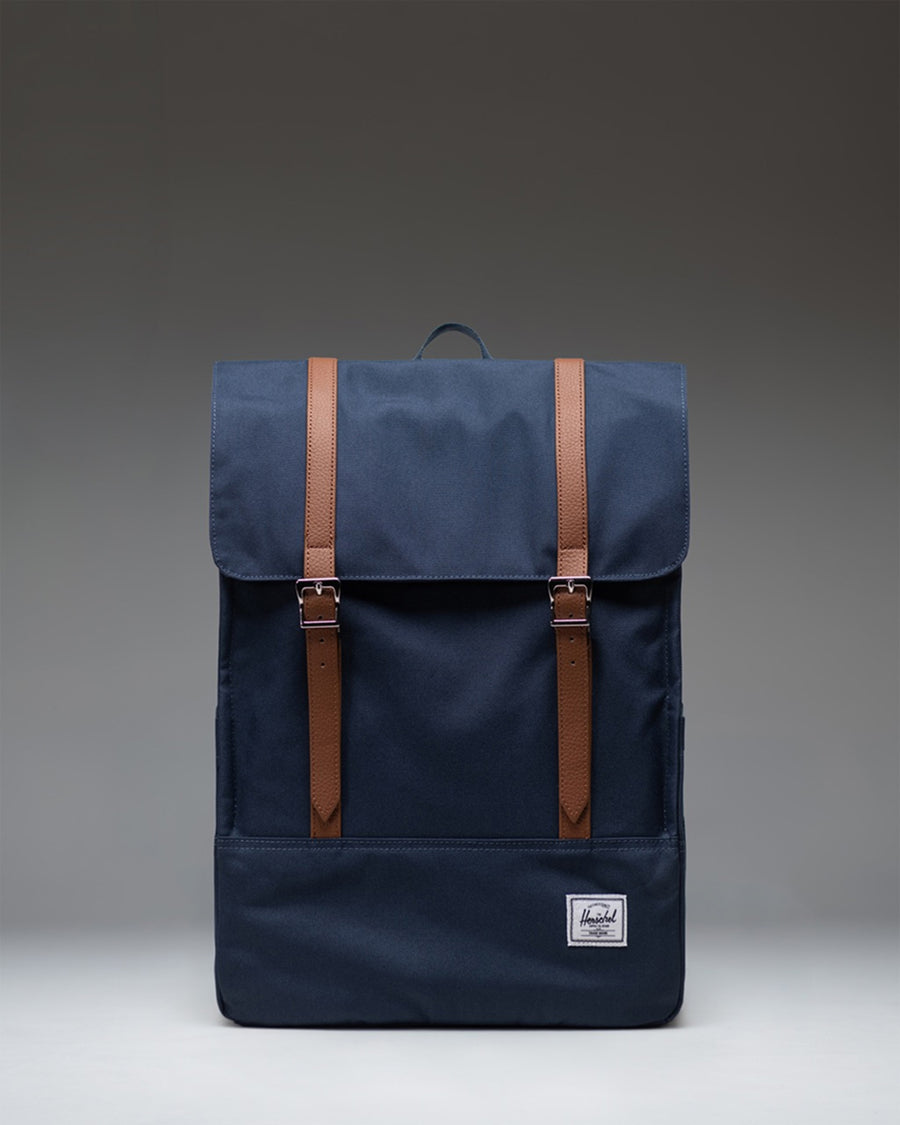Herschel Survey Backpack in navy blue, showing the front view with its classic rectangular shape and dual strap closures.