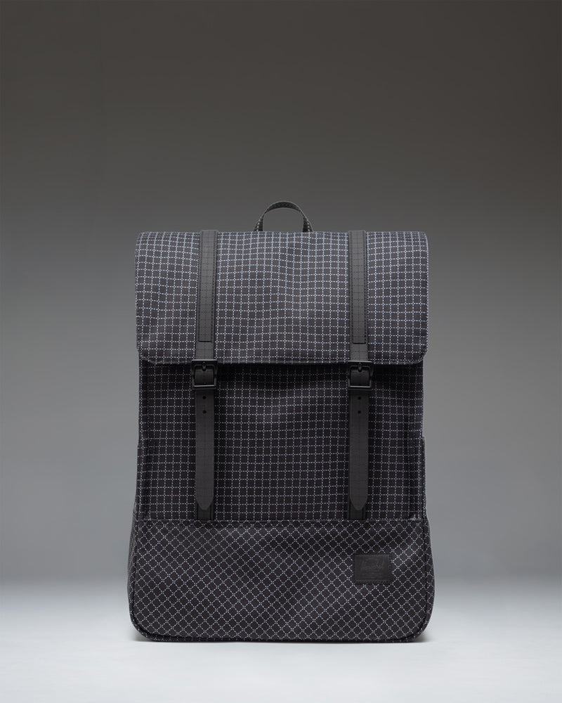 Herschel Survey Backpack in Grid - Black. Front view of the everyday backpack featuring dual magnetic strap closures.