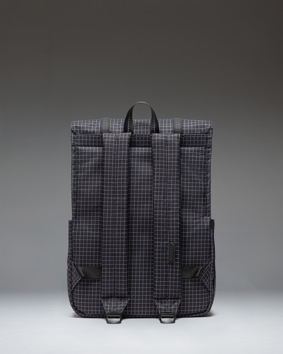 Herschel Survey Backpack in Grid - Black shown from the side, highlighting its slim profile, adjustable shoulder straps, and durable design.