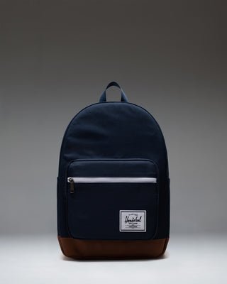 Herschel Supply Co. Pop Quiz Backpack in Navy blue with a brown Tan synthetic leather base and front pocket detail, shown from the front.