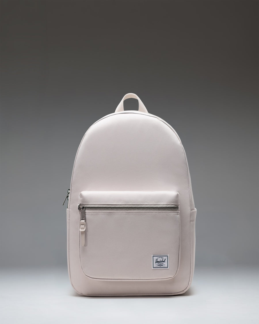 Herschel Supply Co. Settlement Backpack in Moonbeam beige, showing the front view with exposed zippers and a front storage pocket.