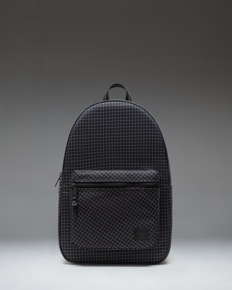 Herschel Supply Co. Settlement Backpack in Grid - Black, shown from the front featuring a modern grid pattern and zippered front pocket.