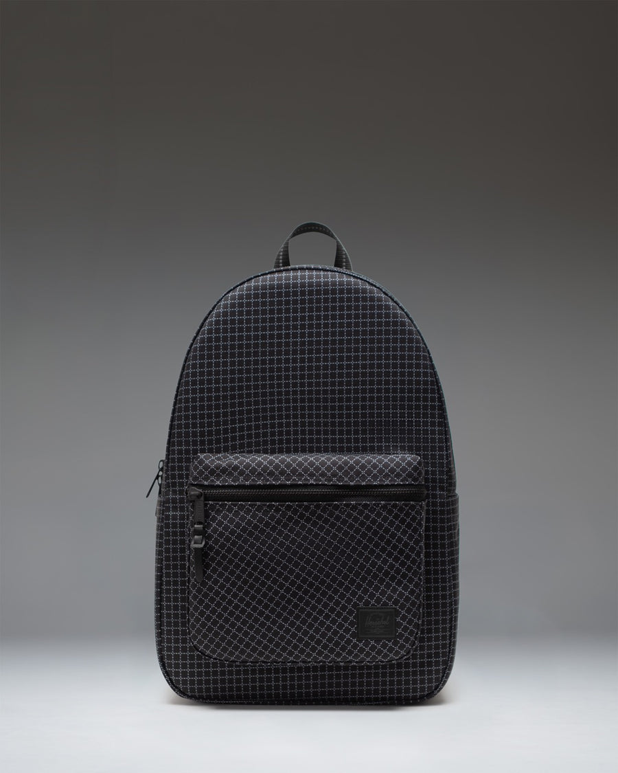 Herschel Supply Co. Settlement Backpack in Grid - Black, shown from the front featuring a modern grid pattern and zippered front pocket.