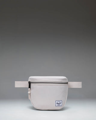 Herschel Supply Co. Settlement Hip Pack in Moonbeam, a light beige waist bag with a front zipper pocket and adjustable strap.