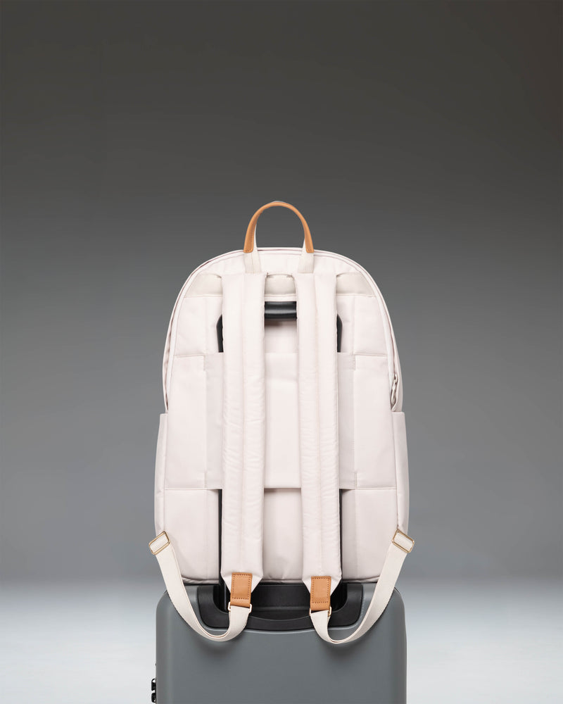 Herschel Supply Co. Beatrix Backpack in Moonbeam colorway showing a sleek design with clean lines, front zippered pocket, and minimalist metal logo.