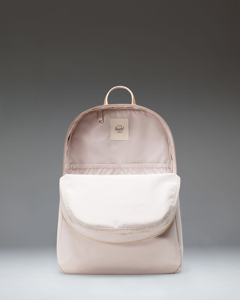 Herschel Supply Co. Beatrix Backpack in Moonbeam colorway featuring a light beige exterior, zippers, top handle, and adjustable shoulder straps.