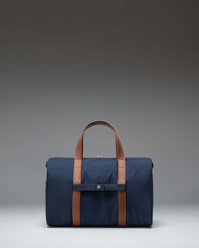 Navy Herschel Novel Carry On Duffle bag featuring a spacious main compartment, signature shoe pocket, and durable top handles.