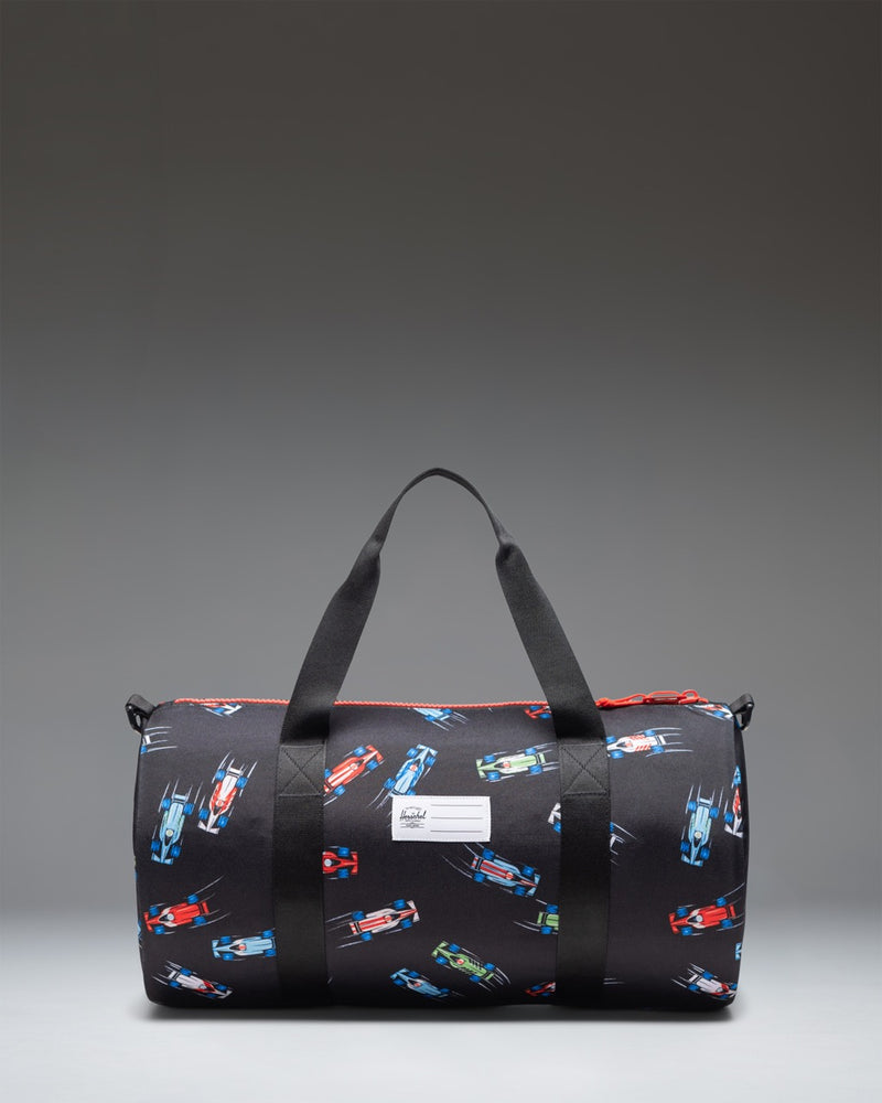 Herschel Classic Duffle Little Herschel in Race Cars colorway featuring a black base pattern with red, yellow, and blue race cars.
