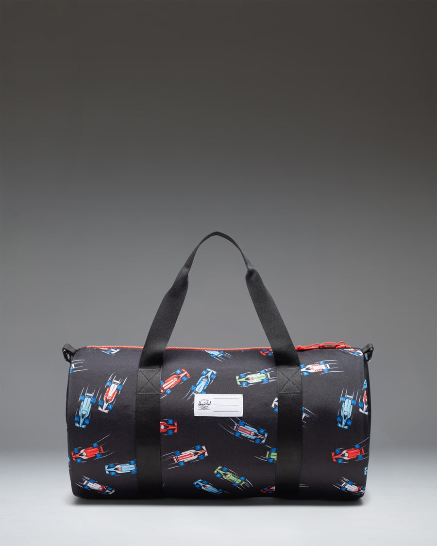 Herschel Classic Duffle Little Herschel in Race Cars colorway featuring a black base pattern with red, yellow, and blue race cars.
