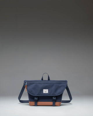 Herschel Supply Co Cove Small Messenger bag in Navy and Saddle Brown, showing a front view with the main flap and strap.