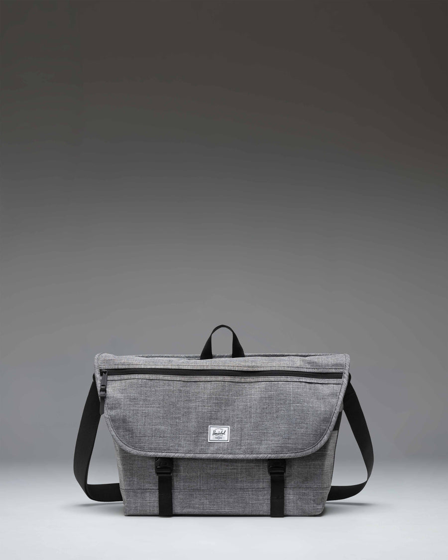 Herschel Supply Co. Cove Messenger bag in Raven Crosshatch grey, showing the front flap, buckle closure, and shoulder strap.
