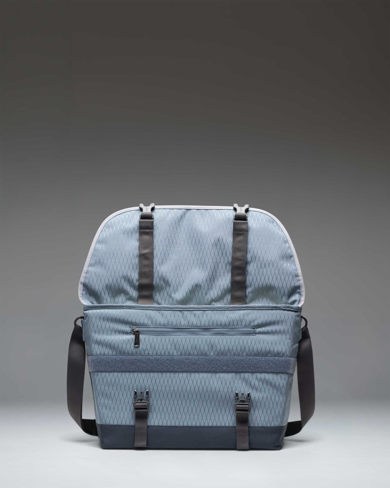 Herschel Supply Co. Cove Messenger bag in Blue Mirage Diamond and Sea Storm blue, showcasing its spacious main compartment and interior pockets.