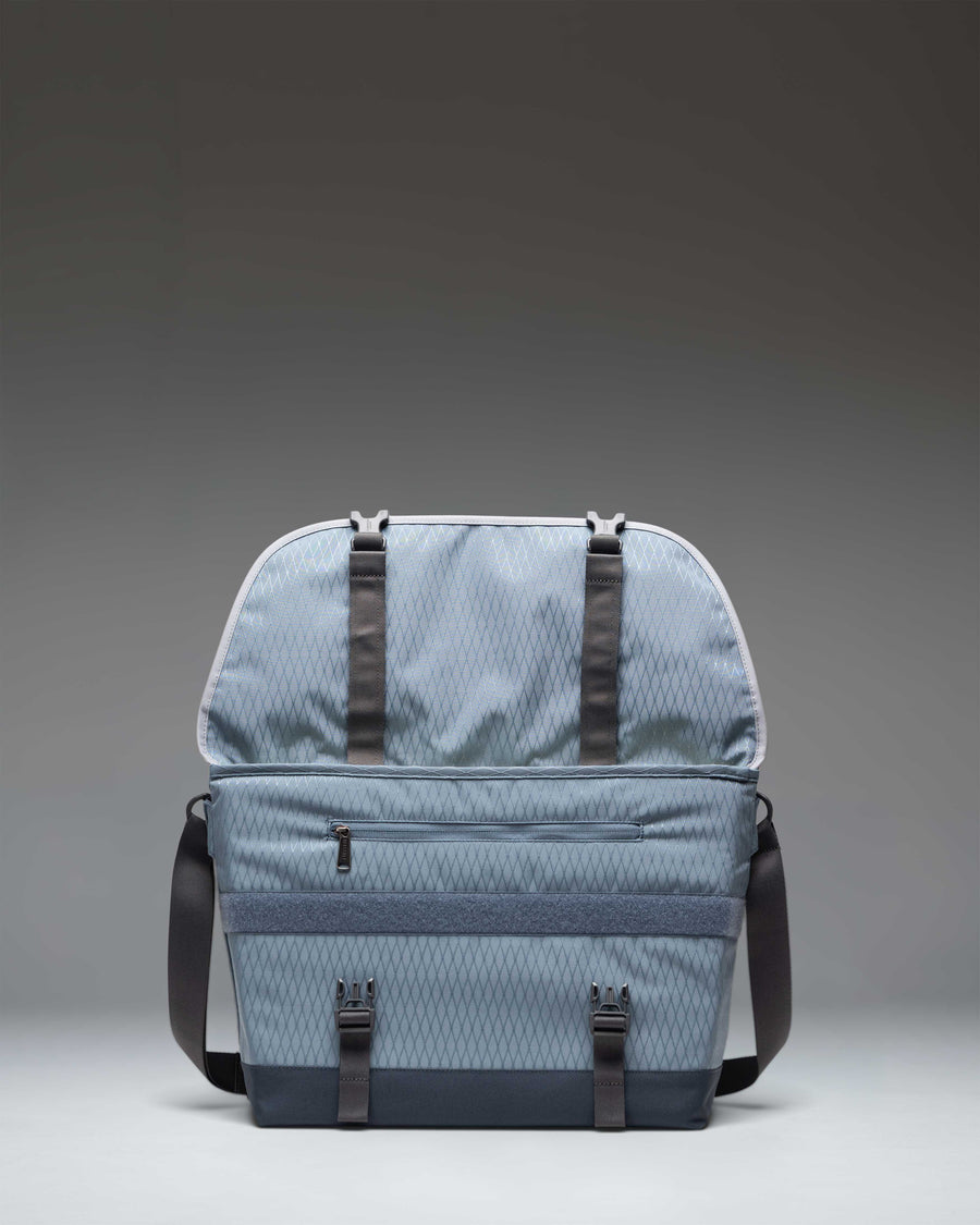 Herschel Supply Co. Cove Messenger bag in Blue Mirage Diamond and Sea Storm blue, showcasing its spacious main compartment and interior pockets.