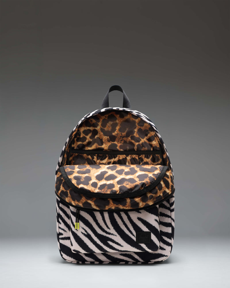 Herschel Classic Backpack in Zebra print featuring a black and white zebra stripe pattern with a black front pocket and straps.