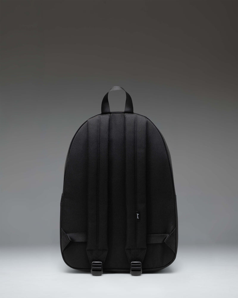 Herschel Classic Backpack in Black Tonal featuring a minimalist design, front zipper pocket, and the signature woven label.