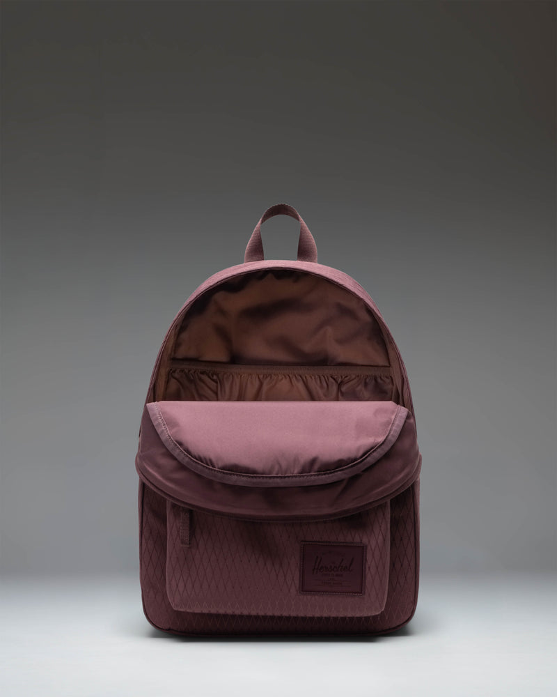 Herschel Classic Backpack in Huckleberry Diamond color, featuring a purple-toned checkered diamond pattern with a front pocket and zipper closure.
