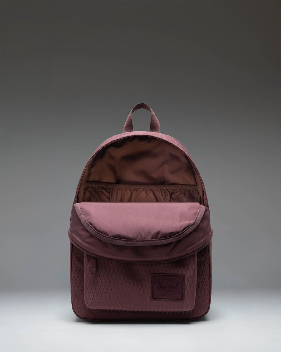 Herschel Classic Backpack in Huckleberry Diamond color, featuring a purple-toned checkered diamond pattern with a front pocket and zipper closure.