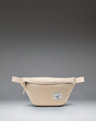 Herschel Classic Hip Pack in Eucalyptus green, showing a compact waist bag with an adjustable strap and front zipper pocket.