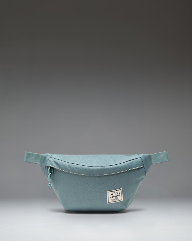 Herschel Classic Hip Pack, a compact 1L waist pack featuring a zippered main closure with a Prusik cord pull and an adjustable webbing strap.