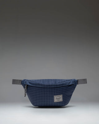 Herschel Classic Hip Pack in Grid Naval Academy/Magnet colorway, showcasing its compact, multi-pocket design.