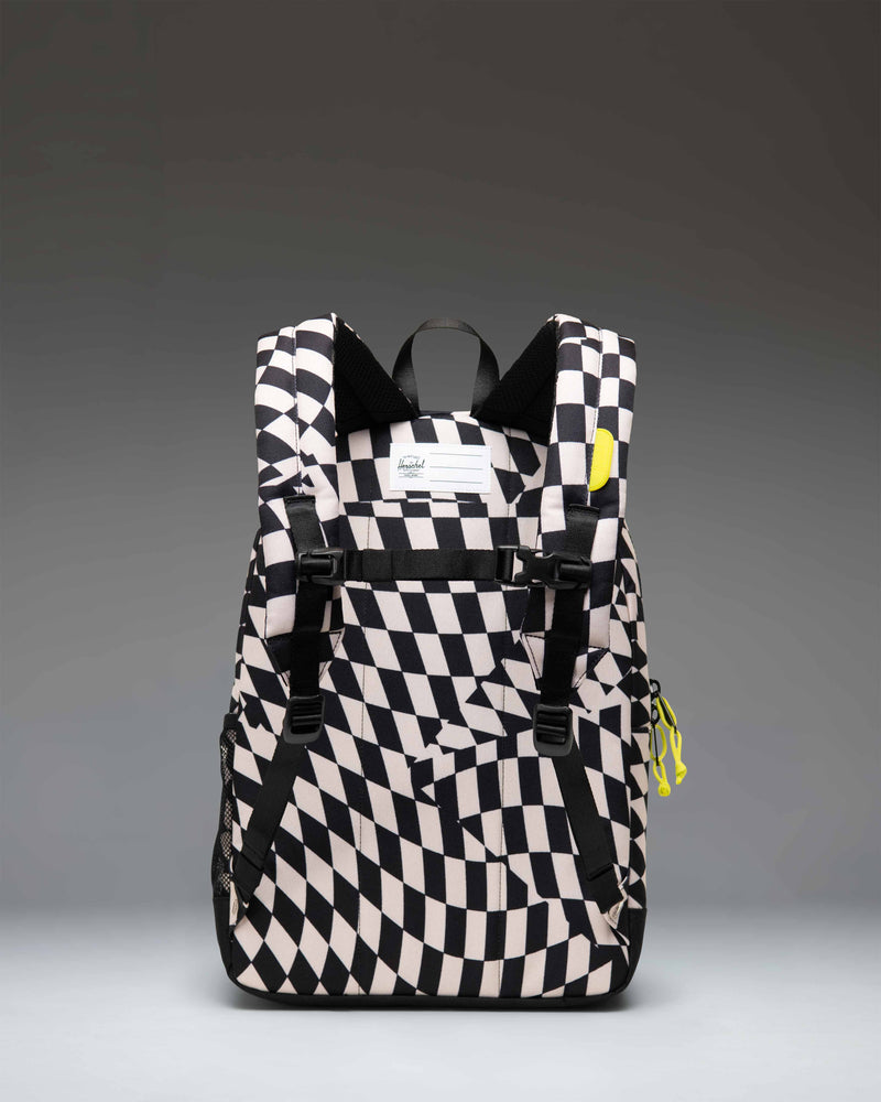 Herschel Heritage Youth Backpack in Warp Check pattern, featuring a black and white checkerboard design with distorted wavy lines.