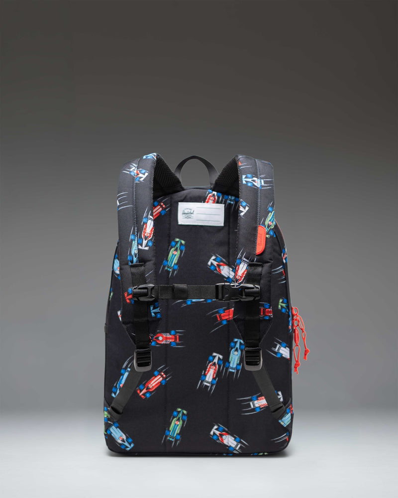 Herschel Heritage Youth Backpack in the Race Cars pattern featuring colorful race car graphics over a dark background.