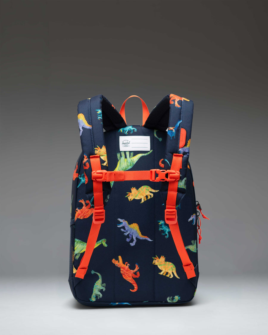 Herschel Supply Co. Heritage Youth Backpack featuring a colorful watercolor dinosaur pattern on a darkest navy blue background.