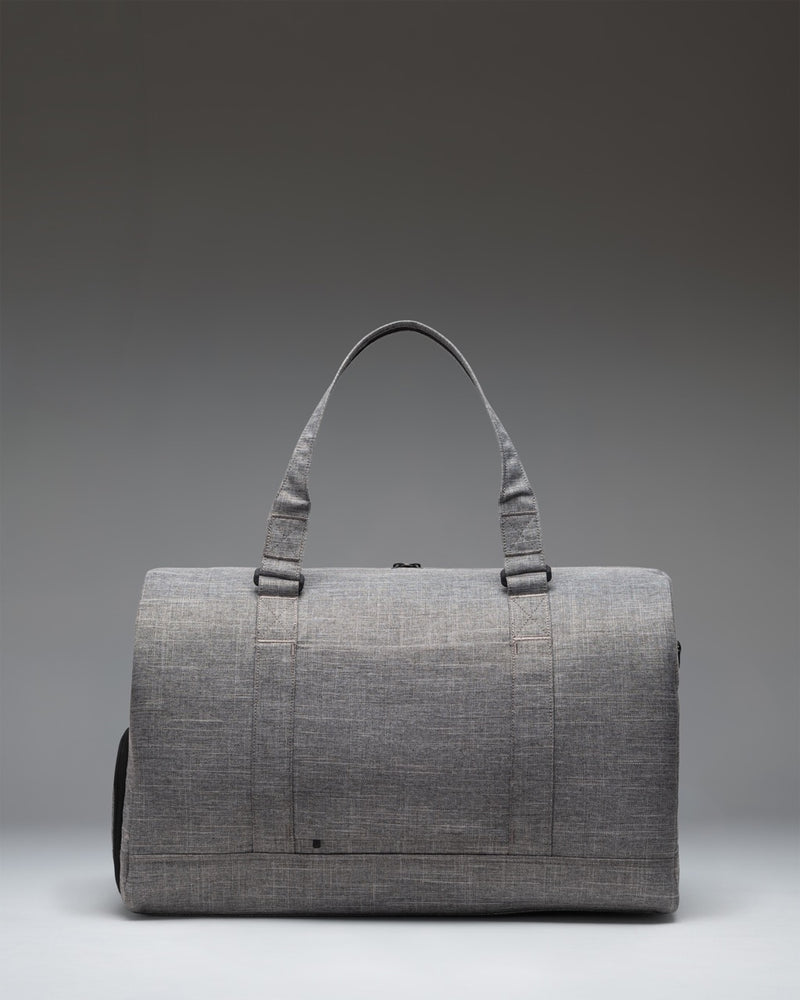 Herschel Novel Duffle Tech bag in Raven Crosshatch grey, showing the side profile view with the signature shoe compartment zip.