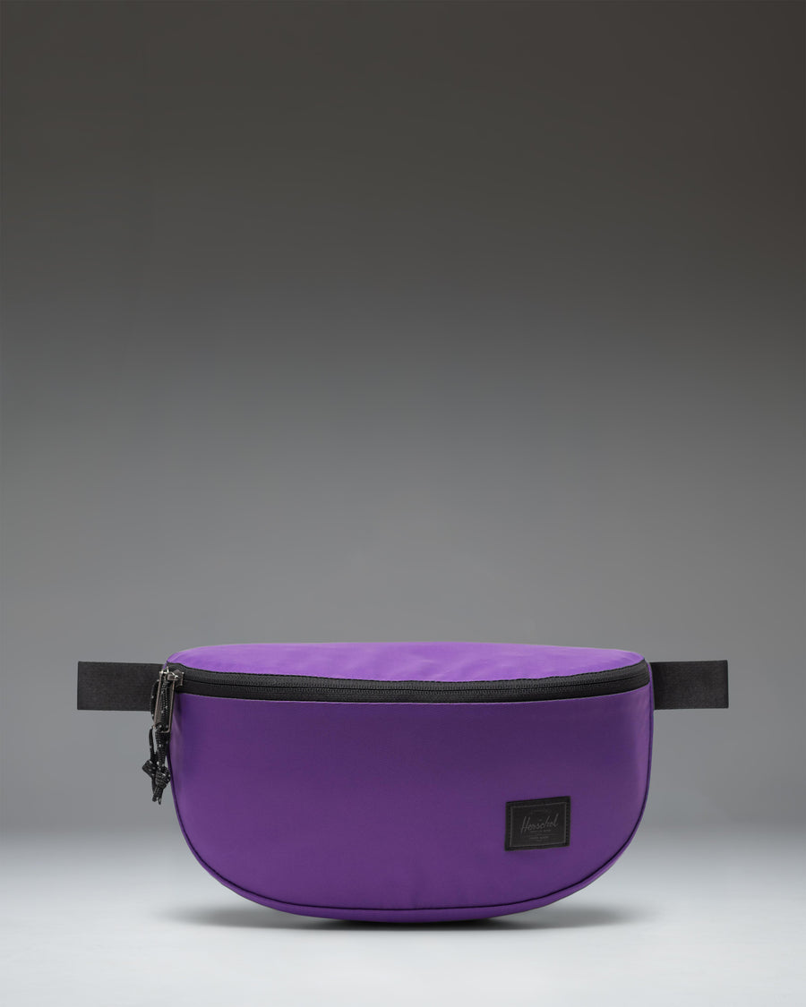 Herschel Supply Co. Kaine Hip Pack in Acai purple, featuring a zippered main compartment, front pocket, and adjustable strap with buckle.