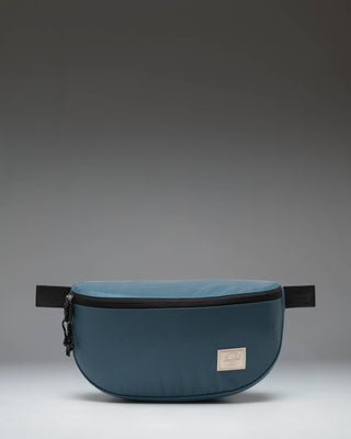 Herschel Supply Co. Kaine Hip Pack in Mediterranea blue, showing a slouchy silhouette with an adjustable strap and zippered closure.