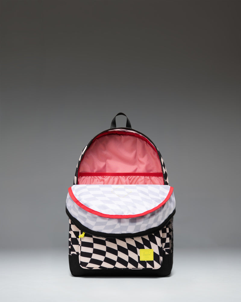 Herschel Heritage Kids Backpack in Warp Check pattern, featuring a black and white distorted checkerboard design with a brown diamond accent.