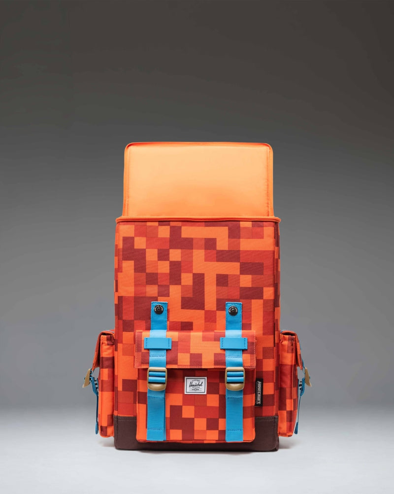 Minecraft Herschel Little America Cube Backpack in Orange Block pattern featuring pixelated dirt and grass graphics with dual orange straps.