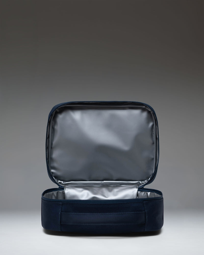 Herschel Supply Co. Pop Quiz Lunch Box in navy blue, showing the front exterior with a zipper pocket and the classic woven label.