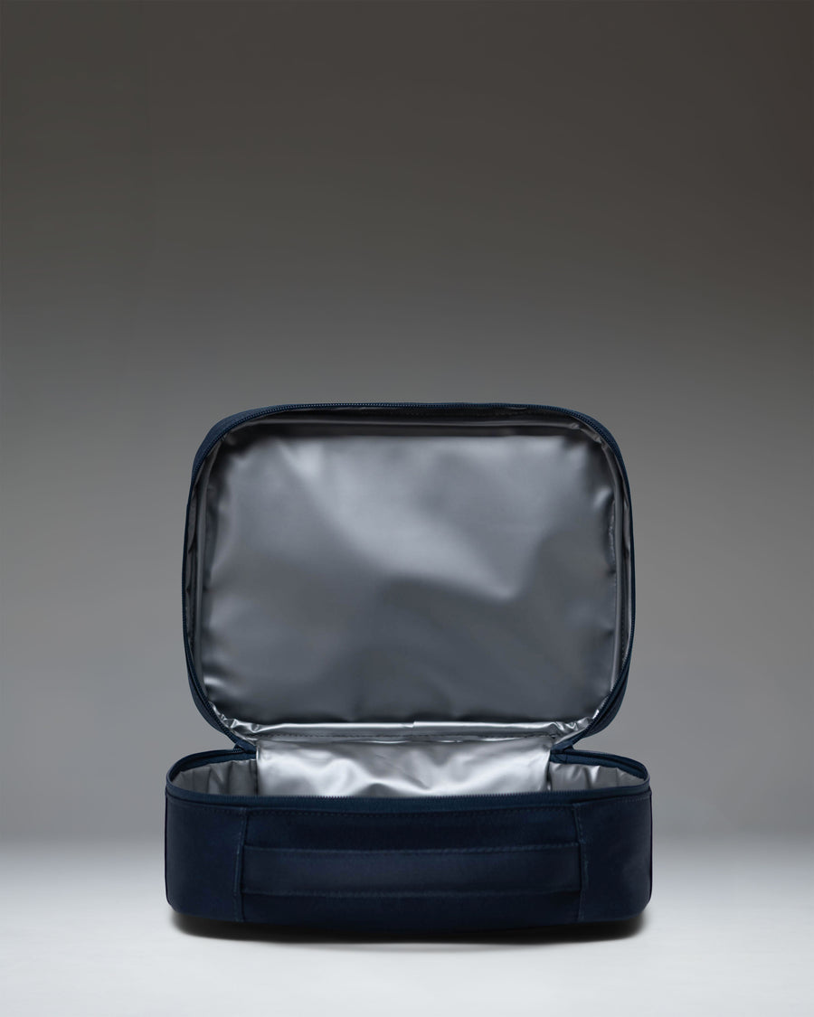 Herschel Supply Co. Pop Quiz Lunch Box in navy blue, showing the front exterior with a zipper pocket and the classic woven label.