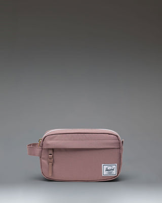 Herschel Supply Co. Chapter Small Travel Kit in Ash Rose, showing the front exterior with a carrying handle and zipper pocket.