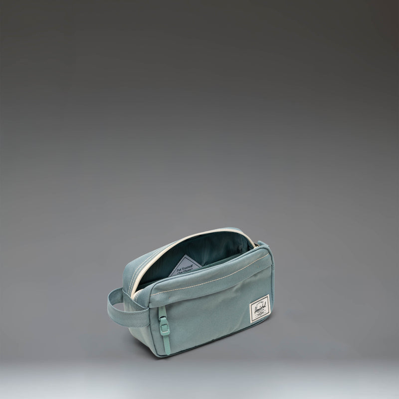 Herschel Supply Co. Chapter Small Travel Kit, showing a compact toiletry bag with a side handle, front zipper pocket, and waterproof main closure.