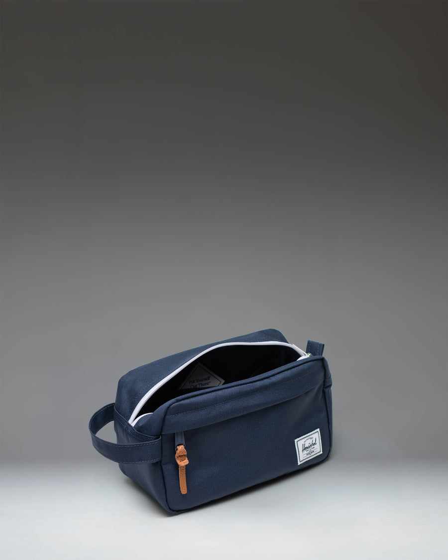 Herschel Supply Co Chapter Travel Kit in navy blue, shown from an angled lifestyle perspective.