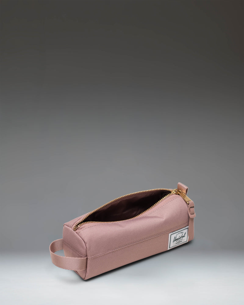 Herschel Supply Co. Settlement Pencil Case in Ash Rose, showing a clean, classic design with a zipper closure and a signature woven label.