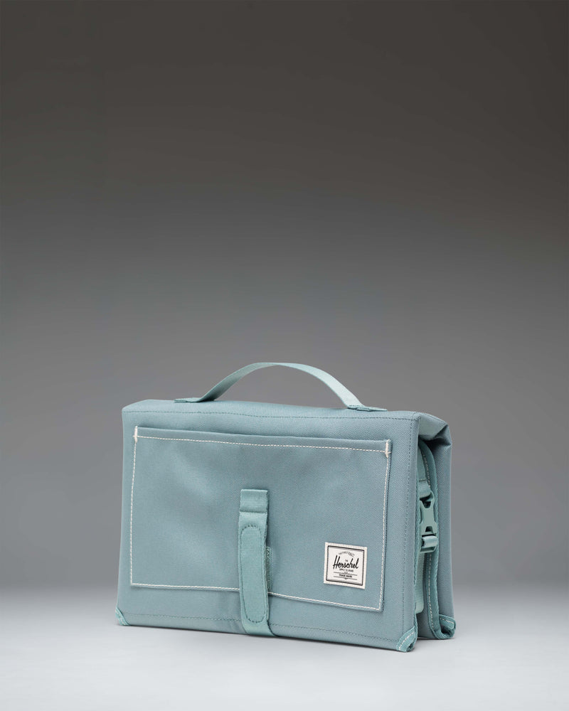 Herschel Supply Co. Sprout Change Mat unfolded as a portable, padded diaper changing station with mesh storage pockets.