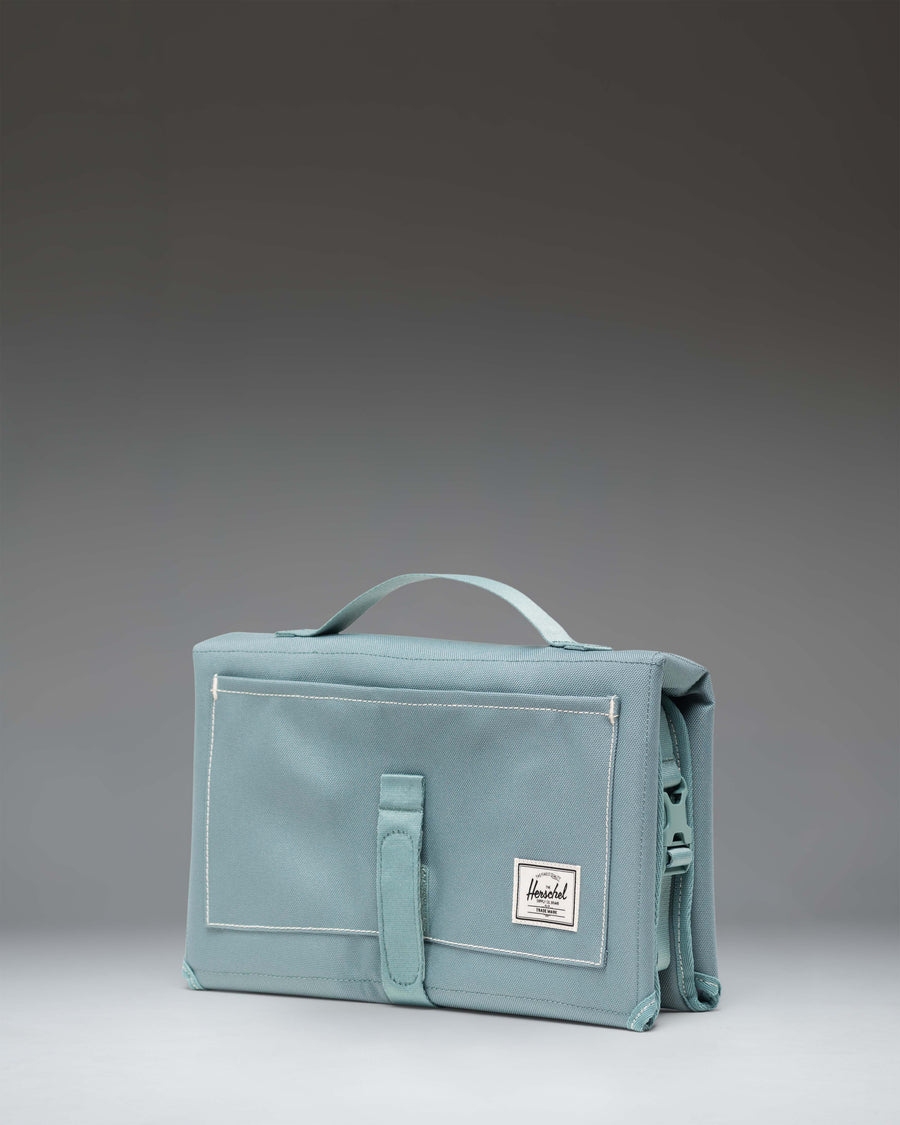 Herschel Supply Co. Sprout Change Mat unfolded as a portable, padded diaper changing station with mesh storage pockets.