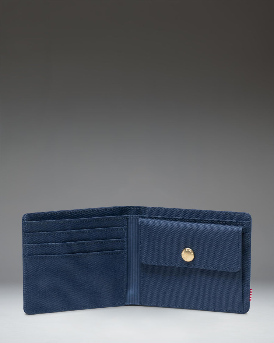 Herschel Supply Co Roy Coin Wallet in navy blue, shown opened flat to display the internal coin pocket and card slots.